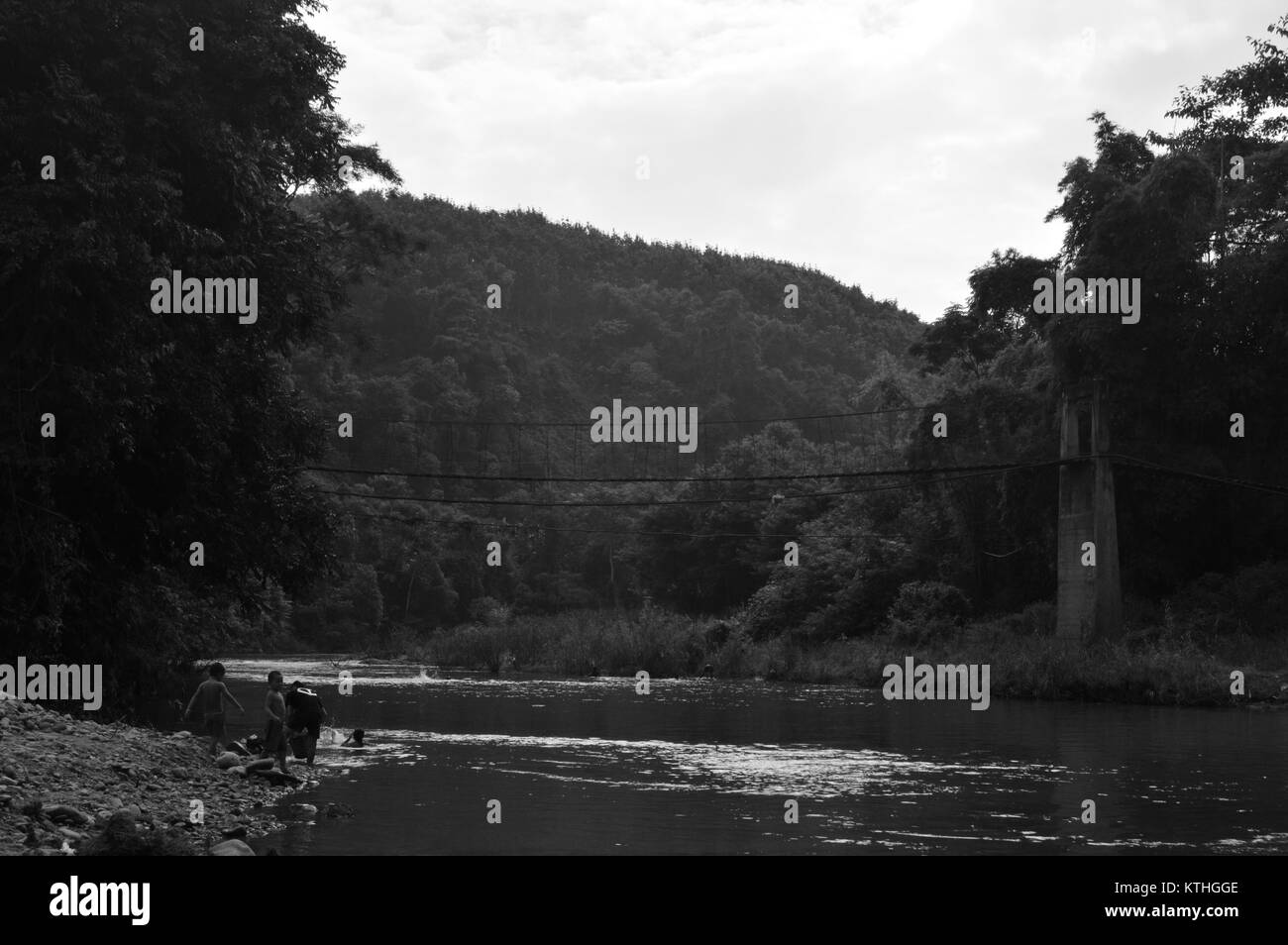 Kids and family playing near river after bathing and washing clothes in Laos - Asia Stock Photo