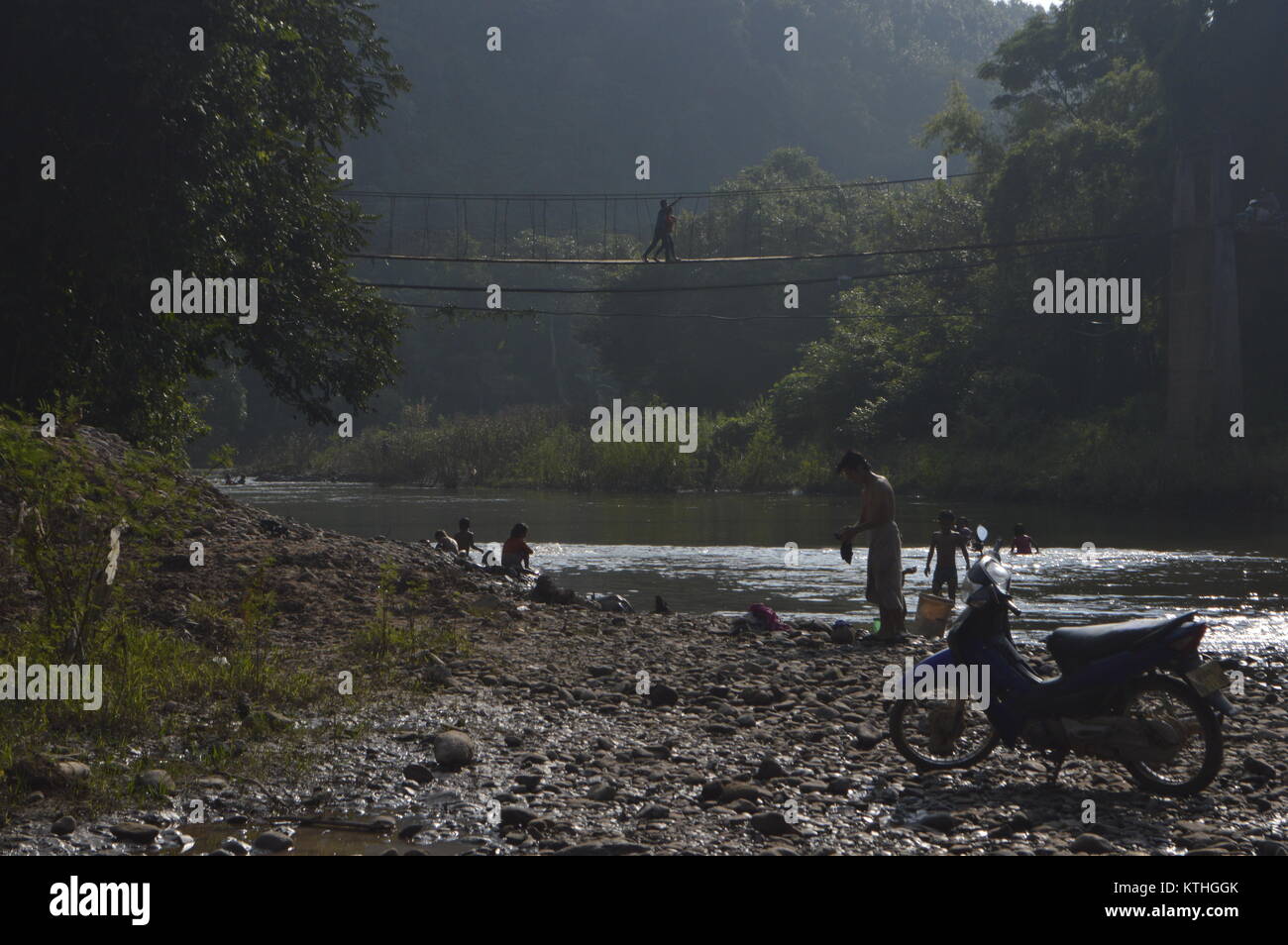 Kids and family playing near river after bathing and washing clothes in Laos - Asia Stock Photo