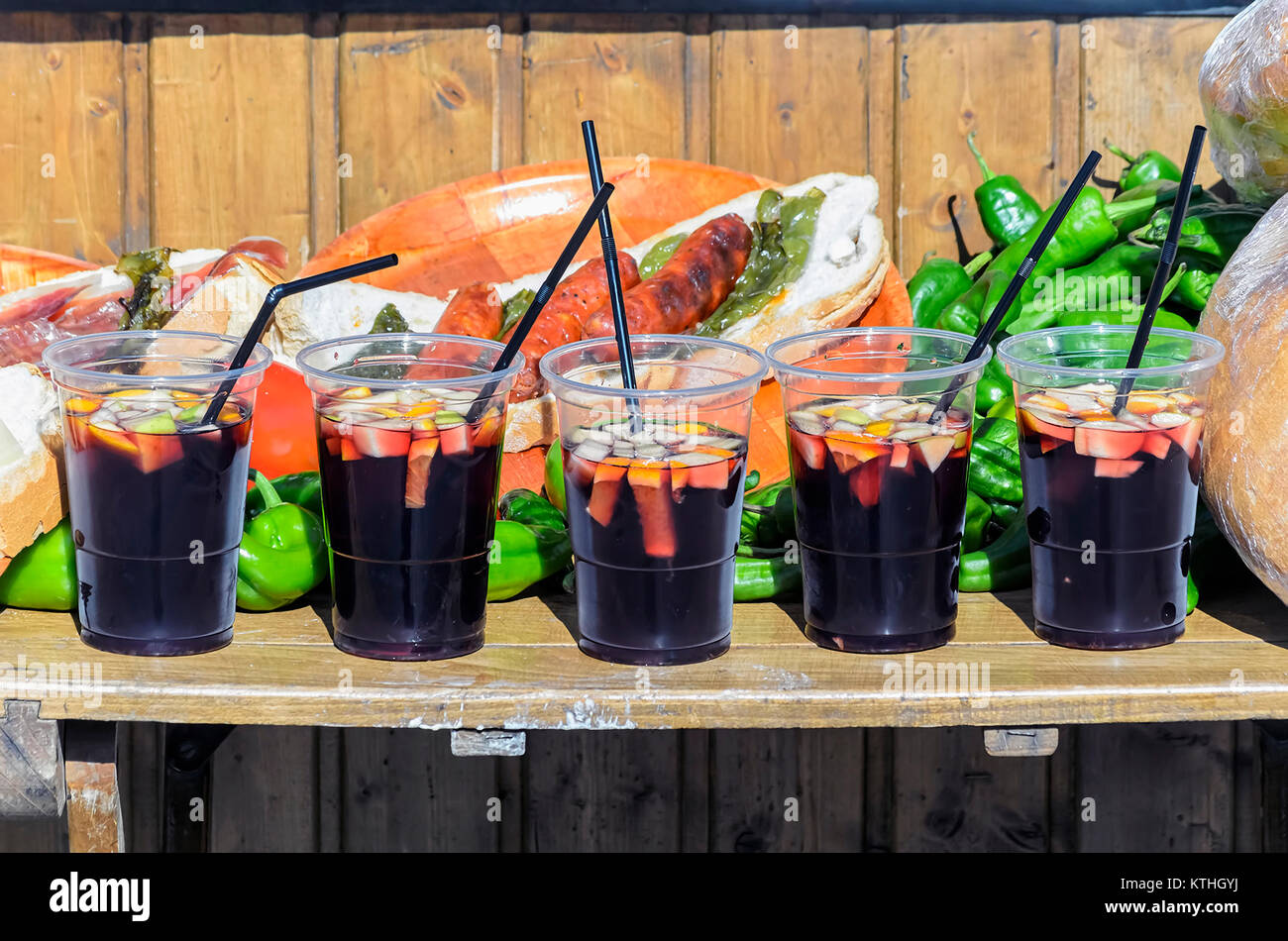 Five big plastic glasses with sangria, typical beverage from Spain. It consists in red wine mixing with chopped fruit (orange & lemon) and some sugar Stock Photo