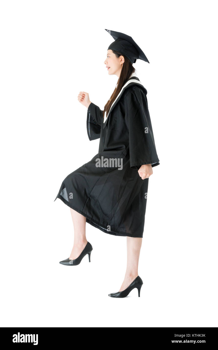 smiling pretty female college graduate student walking up on steps of future career and stepping up expect her successful isolated on white background Stock Photo