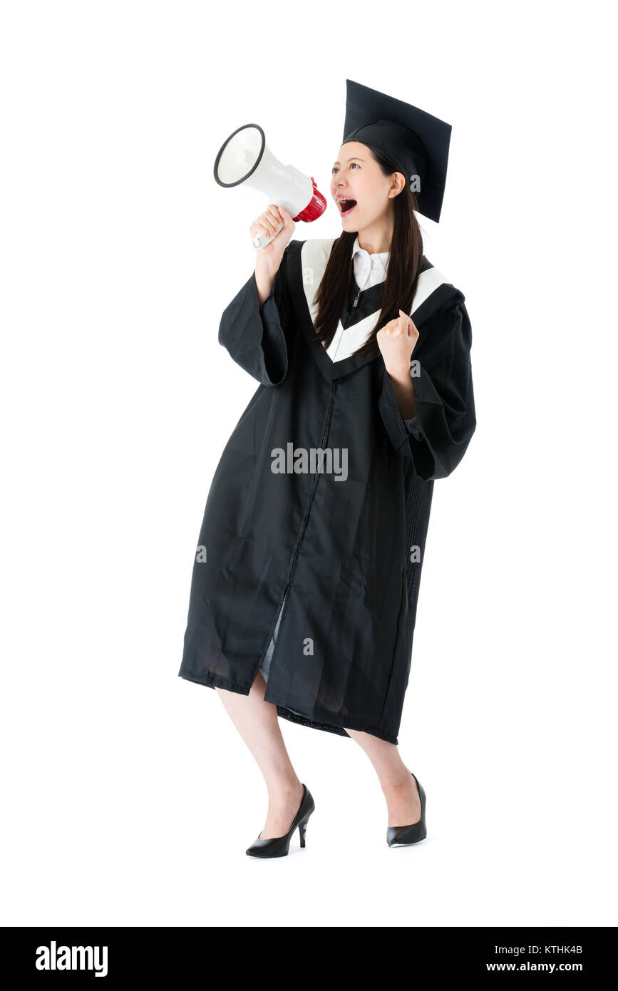 cheerful young female college student using megaphone announced she getting graduation diploma and celebrating on white background. Stock Photo