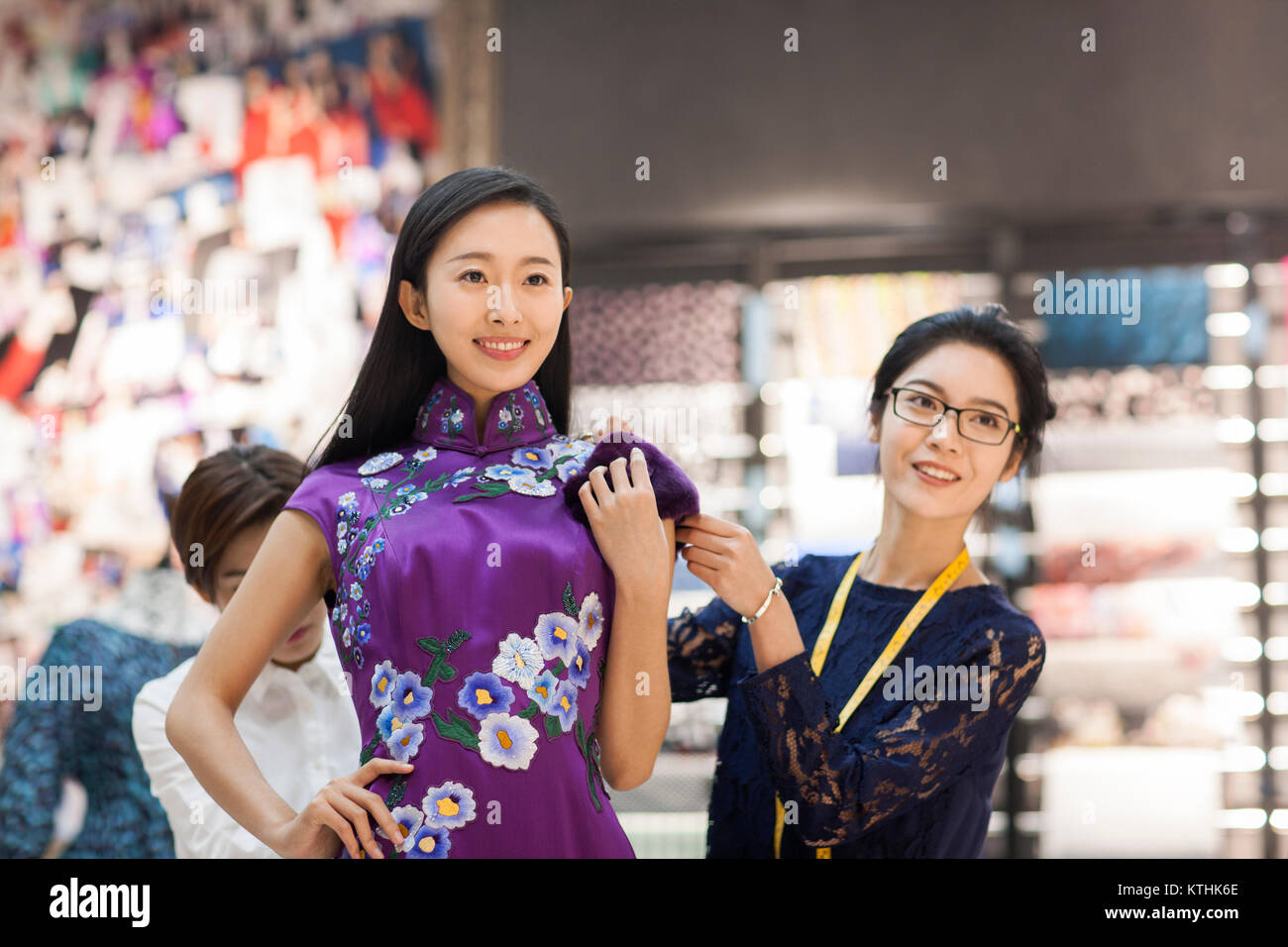 Fashion designers adjusting customer's dress Stock Photo