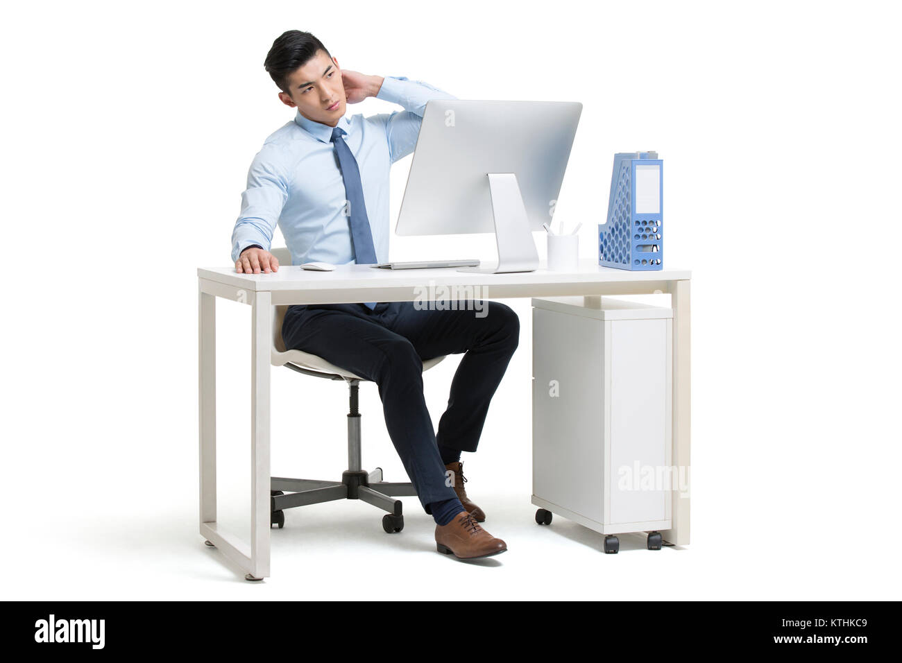 Tired young businessman working in office Stock Photo