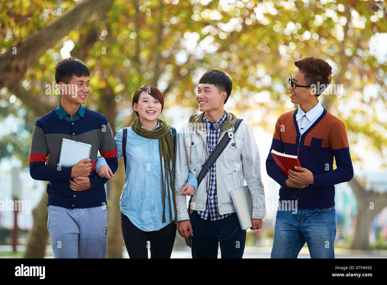 four happy asian college students walking together in the campus Stock ...