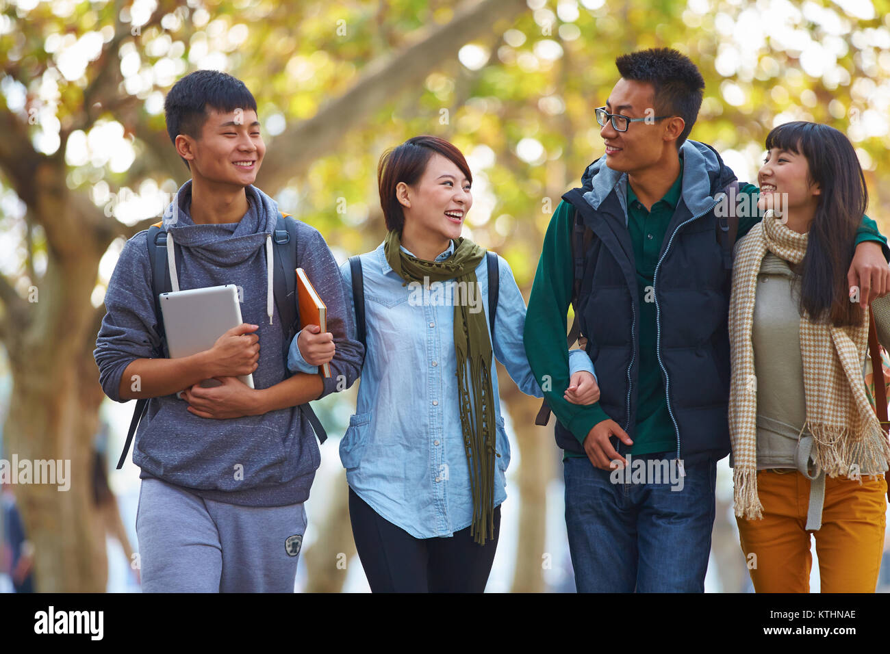 four happy asian college students walking together in the campus Stock ...