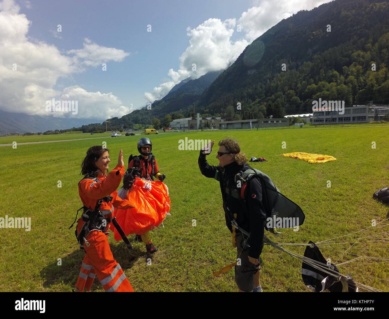 A big smiley face is to see on the tandem skydiving passenger after a successful jump. She is so happy that she would jump immediately again. Stock Photo