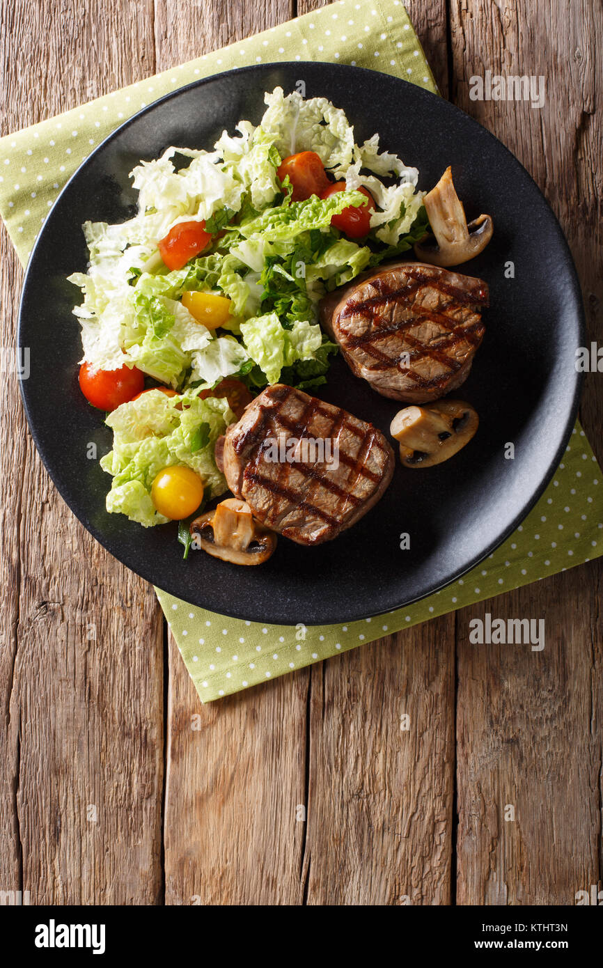 Healthy food filet mignon steak with mushrooms and fresh vegetable salad closeup on a plate