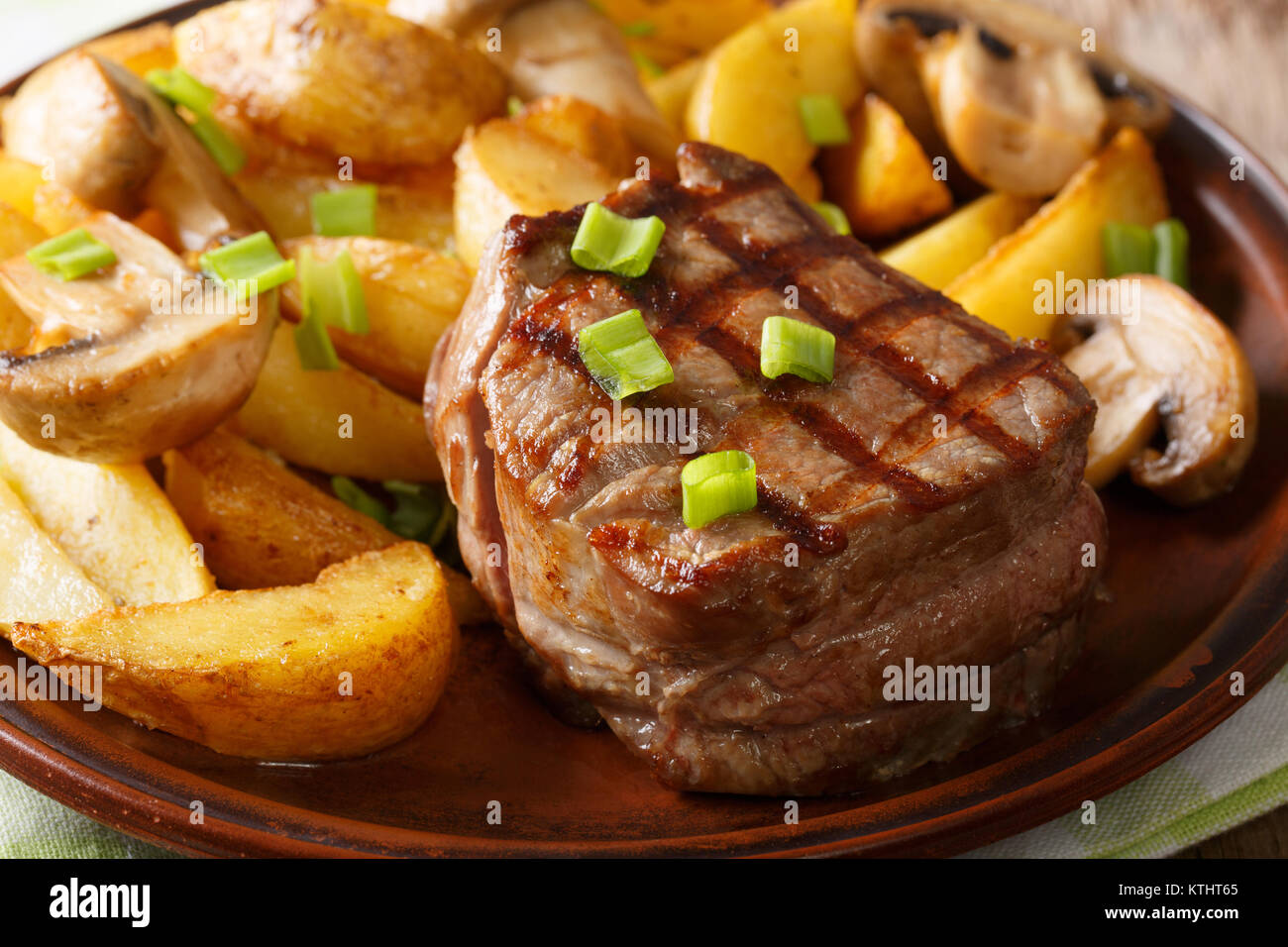 Grilled fillet mignon with potatoes and mushrooms close-up on a plate. horizontal Stock Photo
