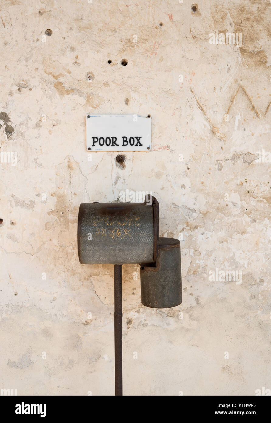 Old ornate poor box fixed to wall of old church Stock Photo