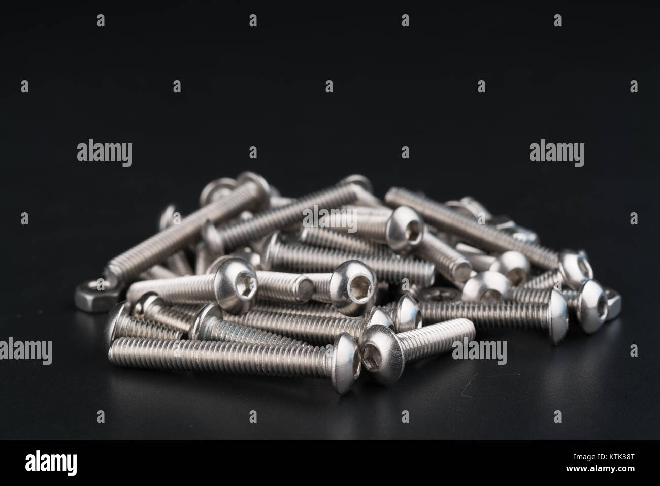 metal fasteners screws and nuts on black background. screw isolated on