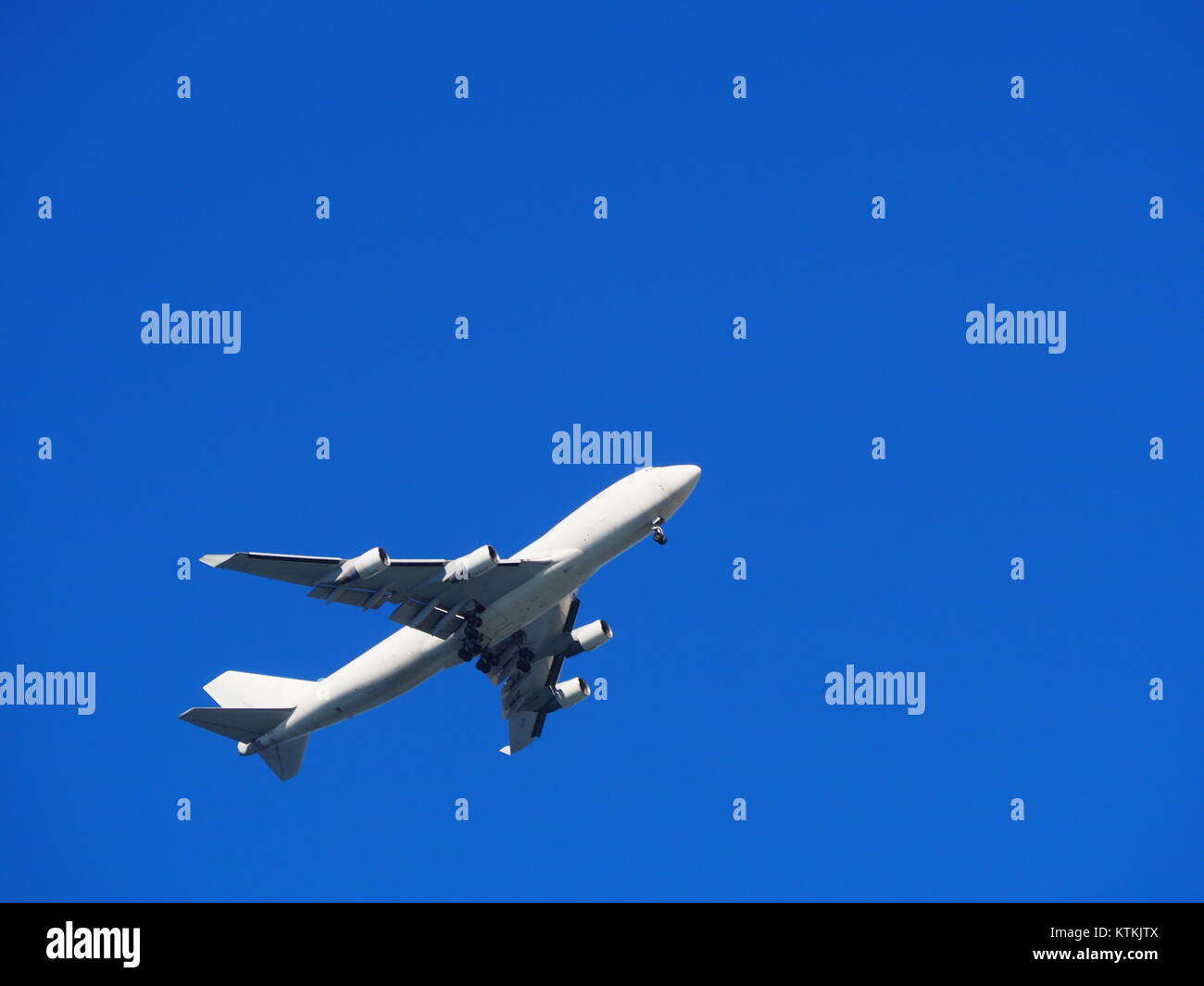 an airplane taking off on a clear blue sky Stock Photo