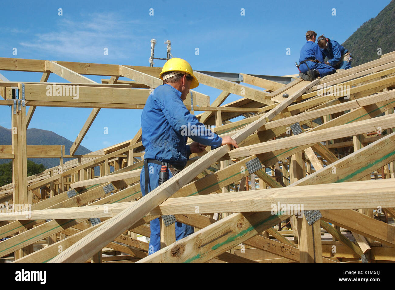 builders working on the roof of a large house Stock Photo Alamy