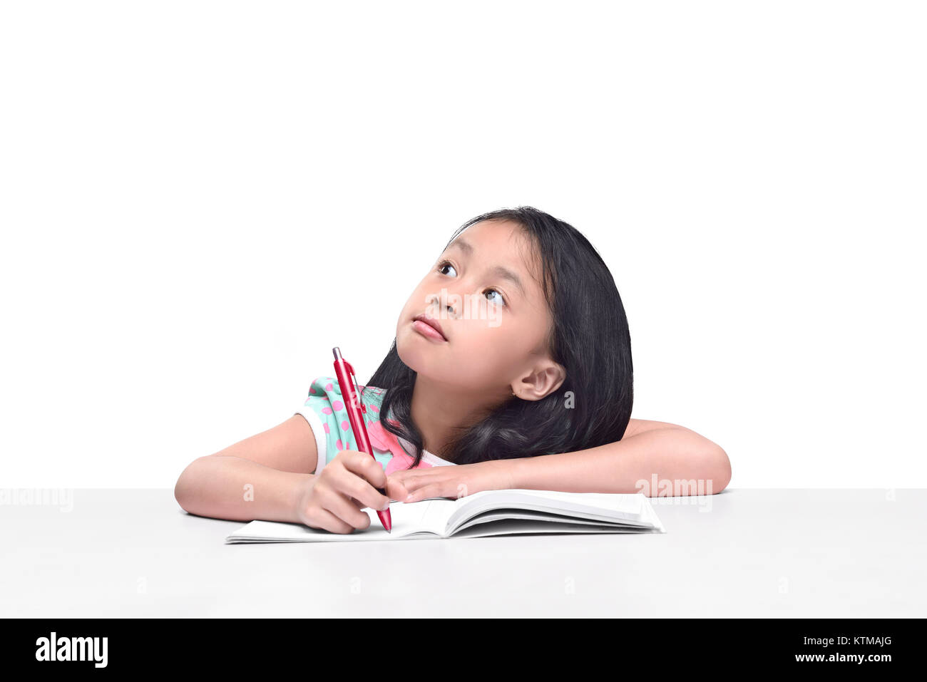 Portrait of asian little girl with pen write on the notebook posing ...