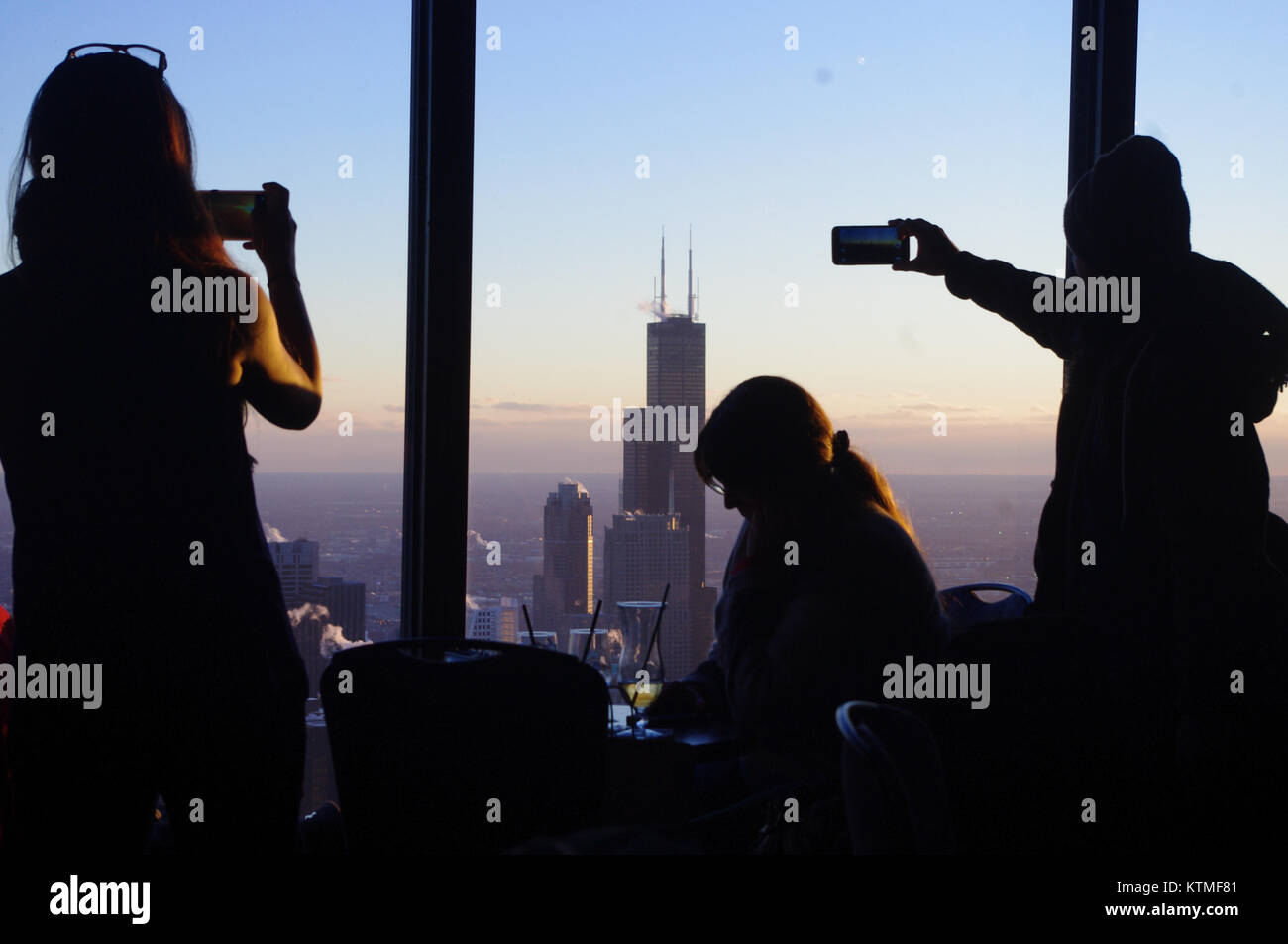 Tourists take photos with their phones from the obsersation deck on the John Hancock building. Chicago, Illinois, USA. Stock Photo