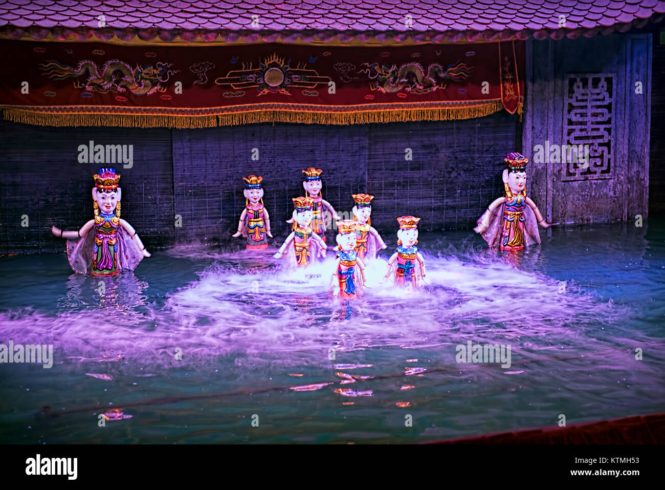 Water puppet show in Vietnam under purple lights Stock Photo