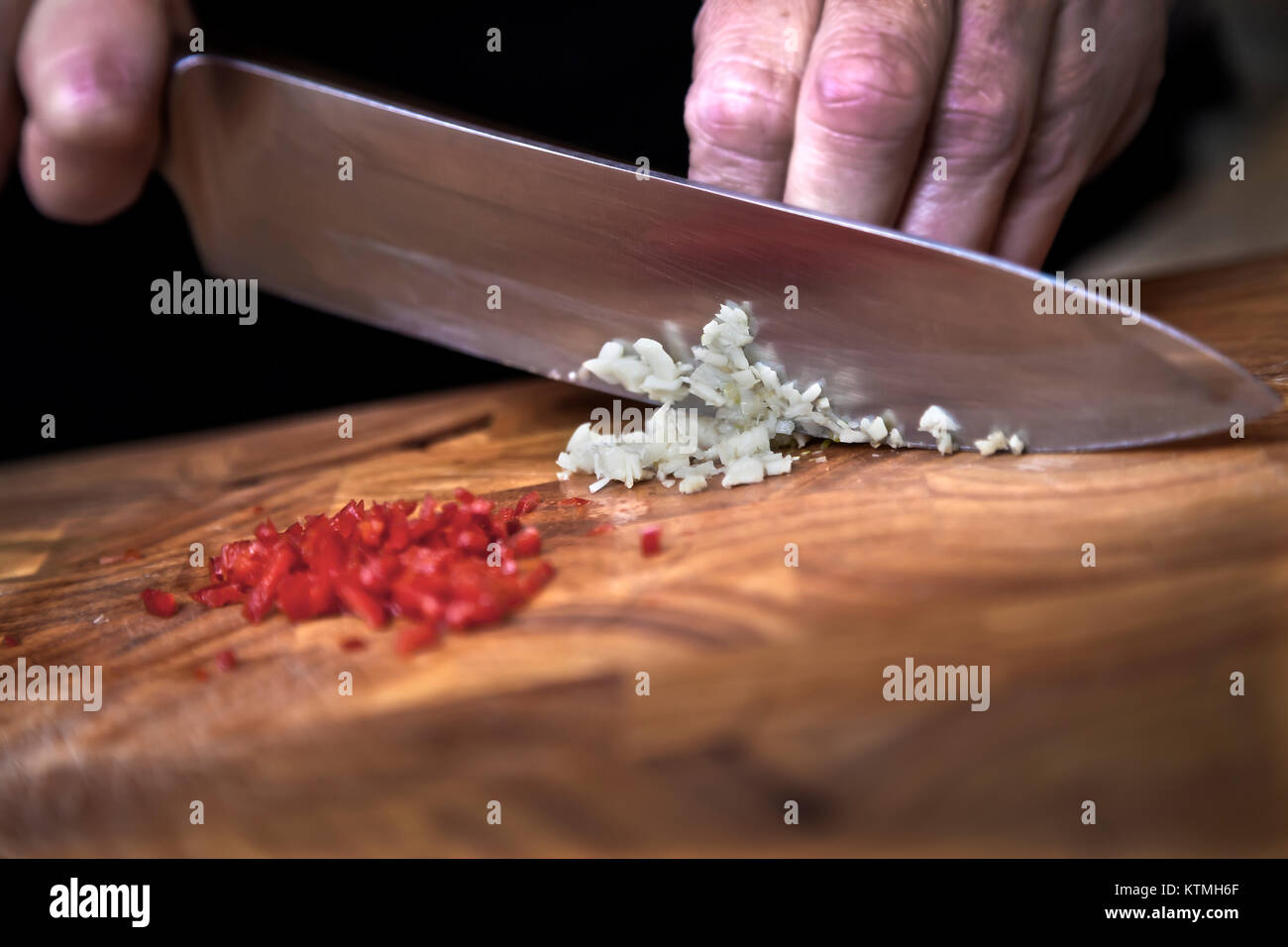 Food preparation - dicing garlic on chopping board Stock Photo