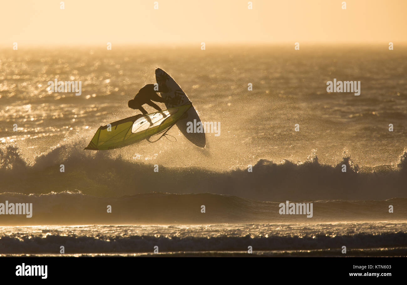 Boardsailing in the sunset in high winds Stock Photo