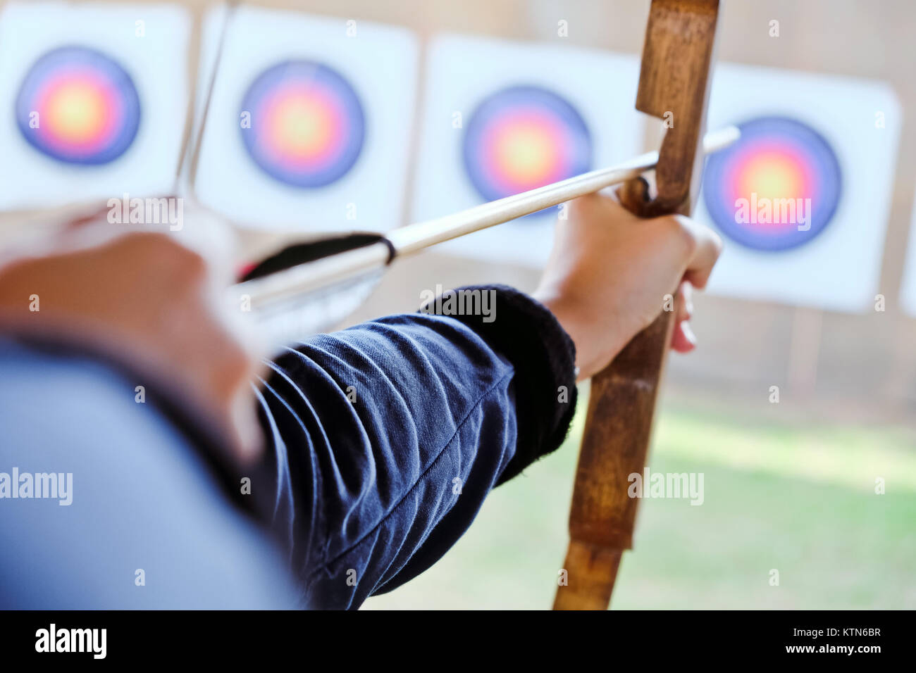 Archer holds his bow aiming at a target Stock Photo - Alamy