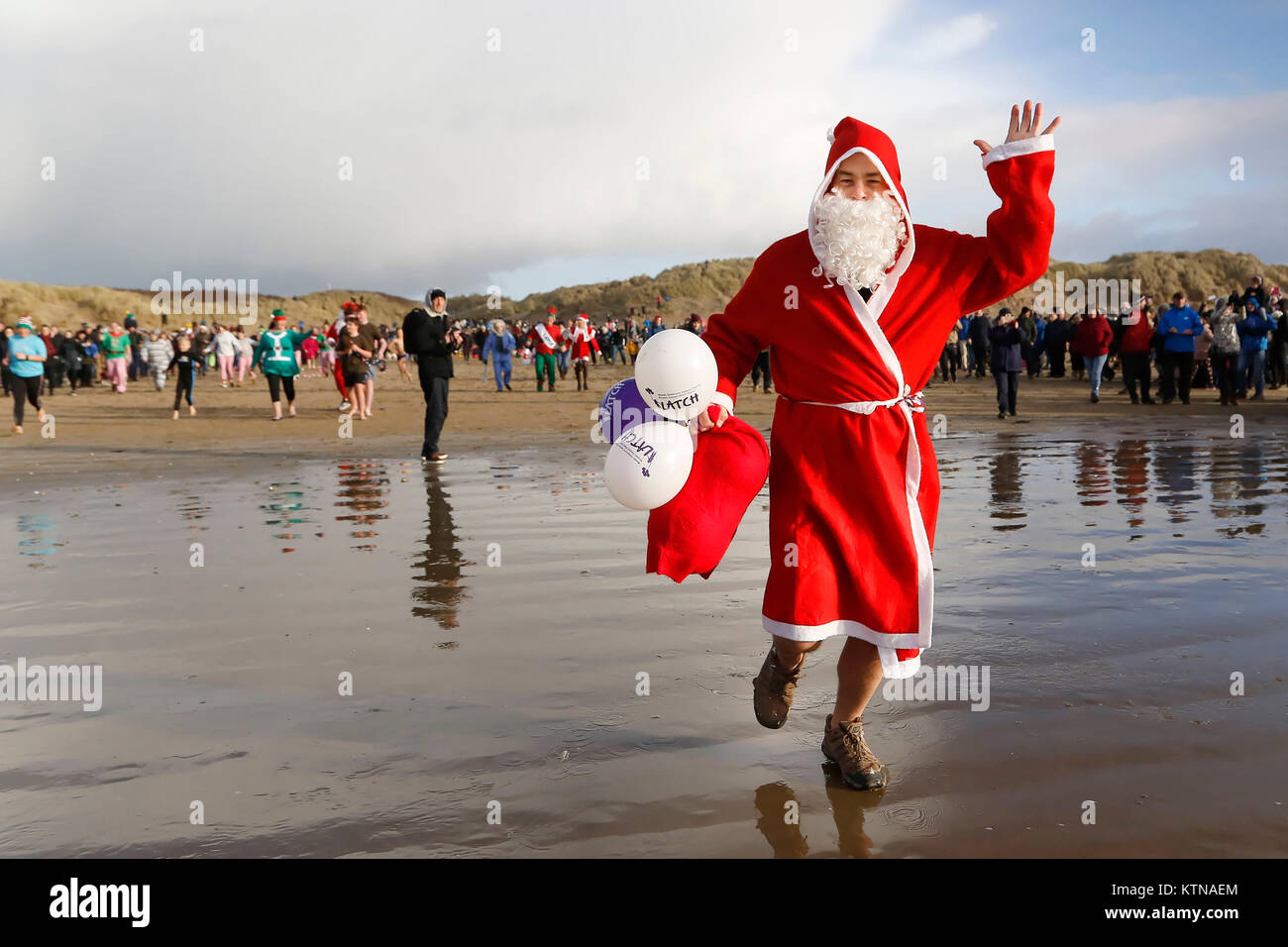 A man in Santa clothes take to the sea Stock Photo