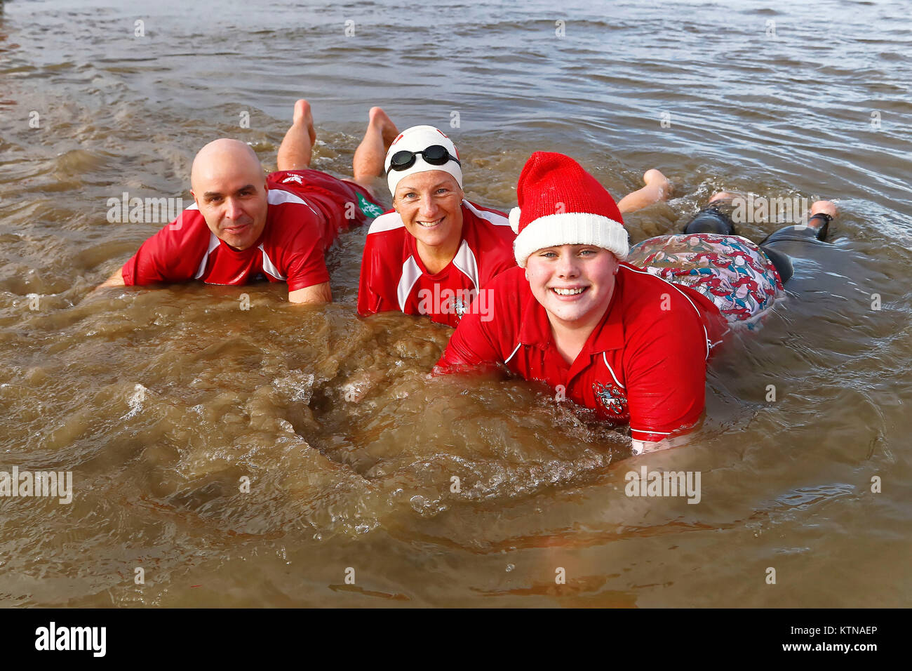 A family in Santa outfits dive in Stock Photo