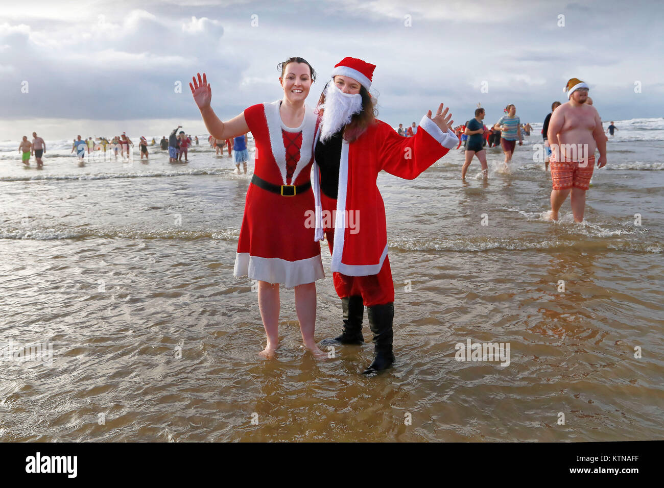 Two women dressed as Santa splash about in the water Stock Photo