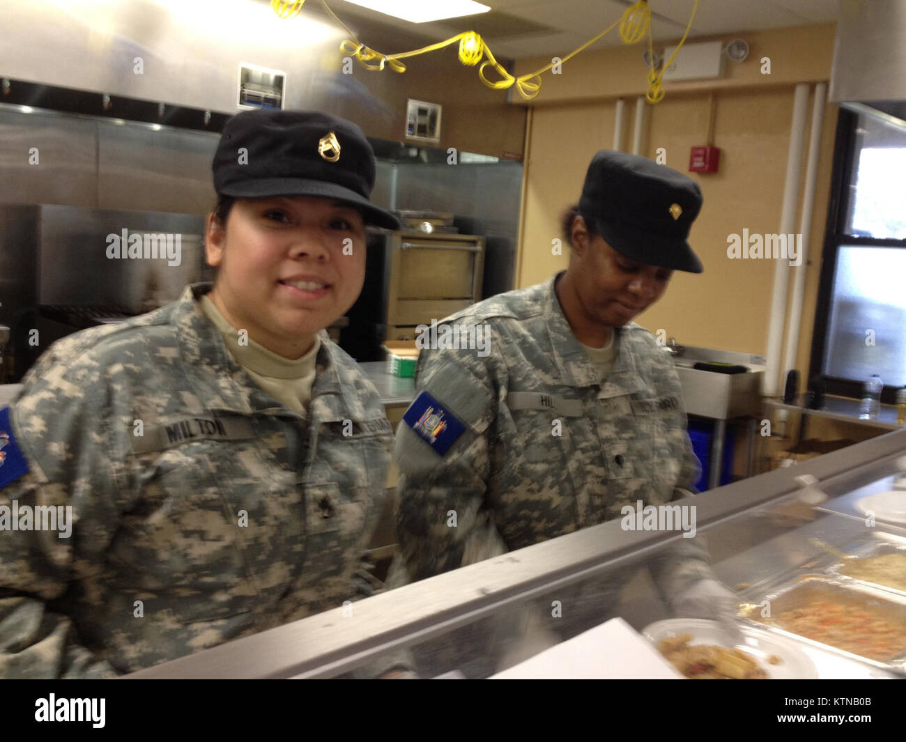 CAMP SMITH, NY - New York Guard Staff Sergeant Fiona Milton, HHC, from Elmhurst, and New York Guard Specialist Grace Hill, HHC, from Nyack, serve up chow on 7 Nov. The NY Guard has provided a team of mess hall personnel to augment the National Guard for JTF Sandy. (Photo by Sergeant First Class Dave Konig, NY Guard) Stock Photo