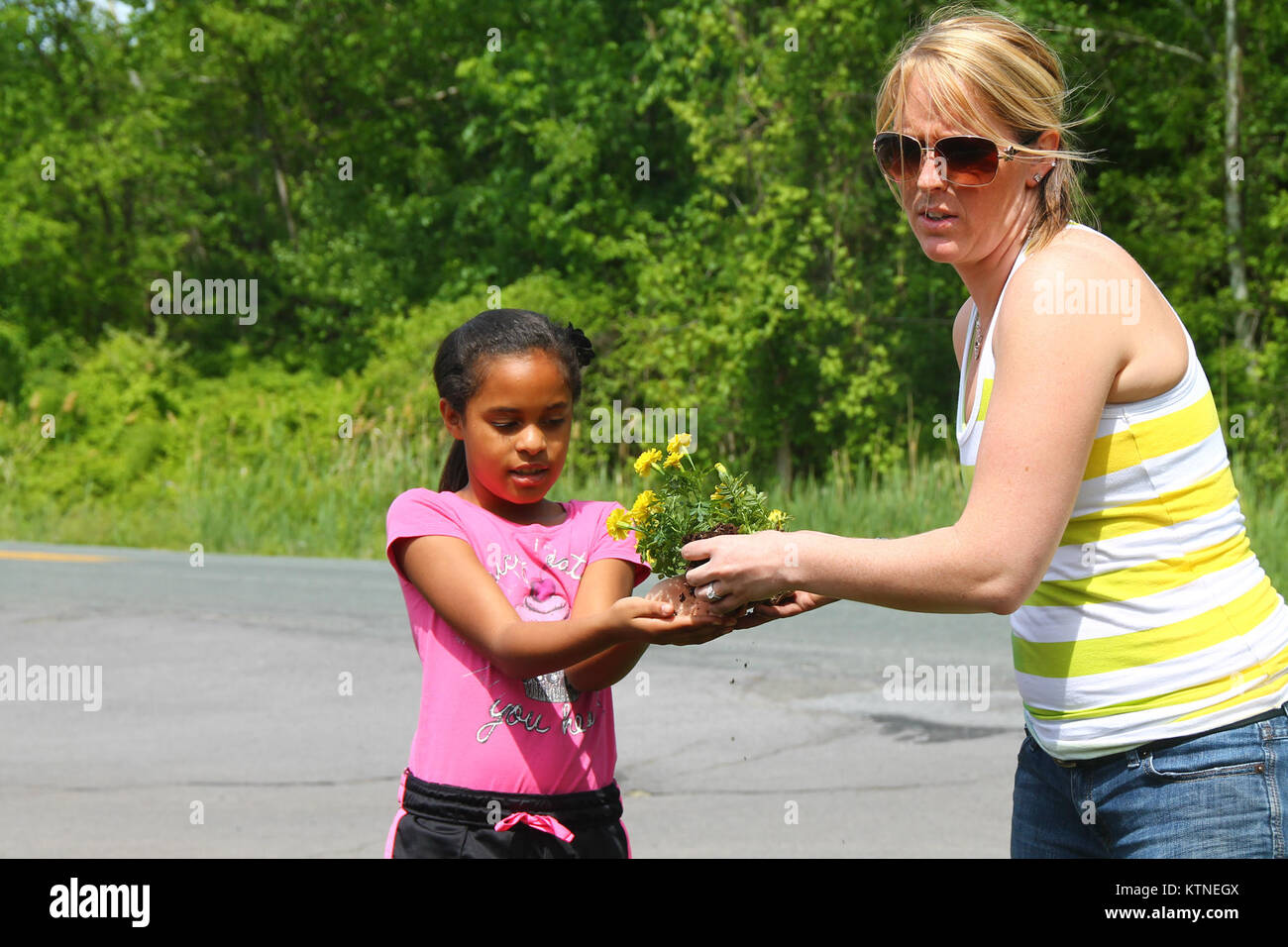 Anastasia Prince, daughter of Marisol Bonilla, and Keri O’Neil help as members of the New York National Guard Youth Program plant a rainbow of red geraniums, yellow marigolds and blue lobelias on Armed Forces Day May 18 at the armory of the 42nd Infantry Division Headquarters in Troy, N.Y. The NYNG Youth Program aims to support children of military-affiliated members and planted flowers in Troy and in Latham, N.Y. (U.S. Army Photo by Spc. J.p. Lawrence, 42nd Infantry Division Public Affairs Office). Stock Photo