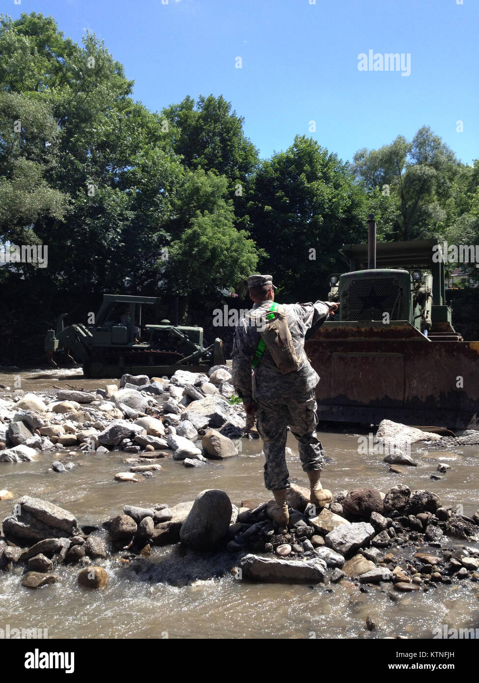 FORT PLAIN, N.Y. -- New York National Guard engineers from Task Force Engineer, a mixed force comprised of forces of the 204th Engineer Battalion, 206th Military Police Company and 1427th Transportation Company assist with debris removal and widening the Otsquago Creek here July 5th following the Guard's recovery support to flash flooding in the Mohawk Valley. The National Guard's initial response force of more than 50 Soldiers on June 28 grew to some 250 Soldiers on July 3 to support local communities in their recovery. U.S. Army photo by Lt. Col. Christopher Panzer, New York National Guard J Stock Photo