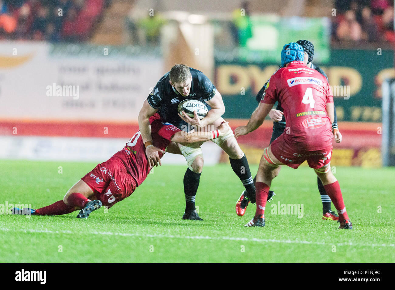 Parc y Scarlets, Llanelli, Wales, UK. Tuesday 26 December 2017. Ospreys lock Bradley Davies is tackled in the Guinness Pro14 match between Scarlets and Ospreys. Credit: Gruffydd Thomas/Alamy Live News Stock Photo