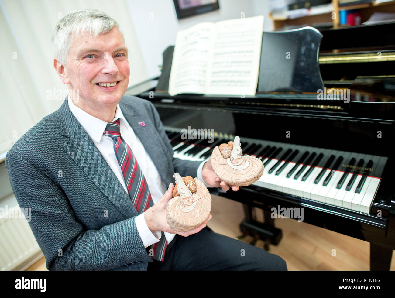 Hannover, Germany. 5th Dec, 2017. The neurologist and expert for music medicine as well as concert musician at the College for Music, Theatre and Media (HMTMH) Professor Eckar Altenmueller holds a model of the halves of the brain in his hand in Hannover, Germany, 5 December 2017. Credit: Hauke-Christian Dittrich/dpa/Alamy Live News Stock Photo