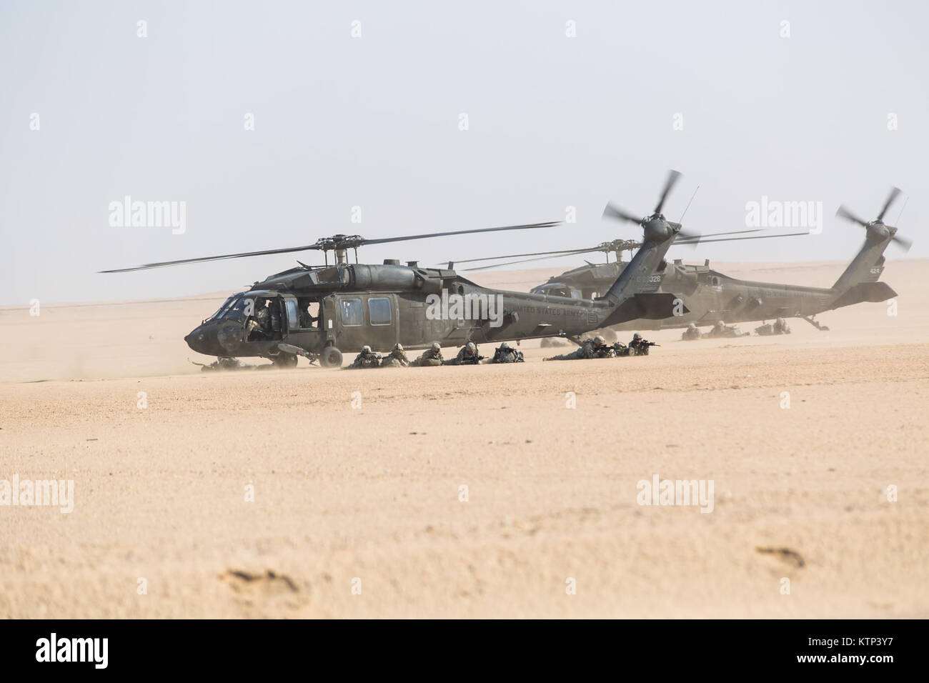 UH-60 Blackhawks from A Co., 3-142nd Assault Helicopter Company, and A. Co., 1-189th General Support Aviation Brigade, 42nd Combat Aviation Brigade, prepare to take off during an air assault with soldiers from A Co., 1-67th Armor Regiment, 2-4th Infantry Division during a training exercise on Dec. 28th, 2013, outside of Camp Buehring, Kuwait.   The 42nd CAB, New York Army National Guard, is currently deployed overseas to operate rotary winged aircraft in support of Operation Enduring Freedom. (U.S. Army photo by Spc. Harley Jelis/Released) Stock Photo