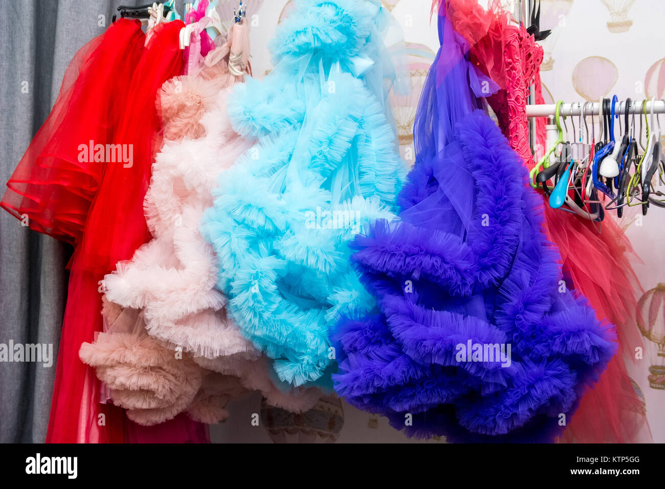 Close-up image of bright colorful dresses hanging on rack in changing room Stock Photo