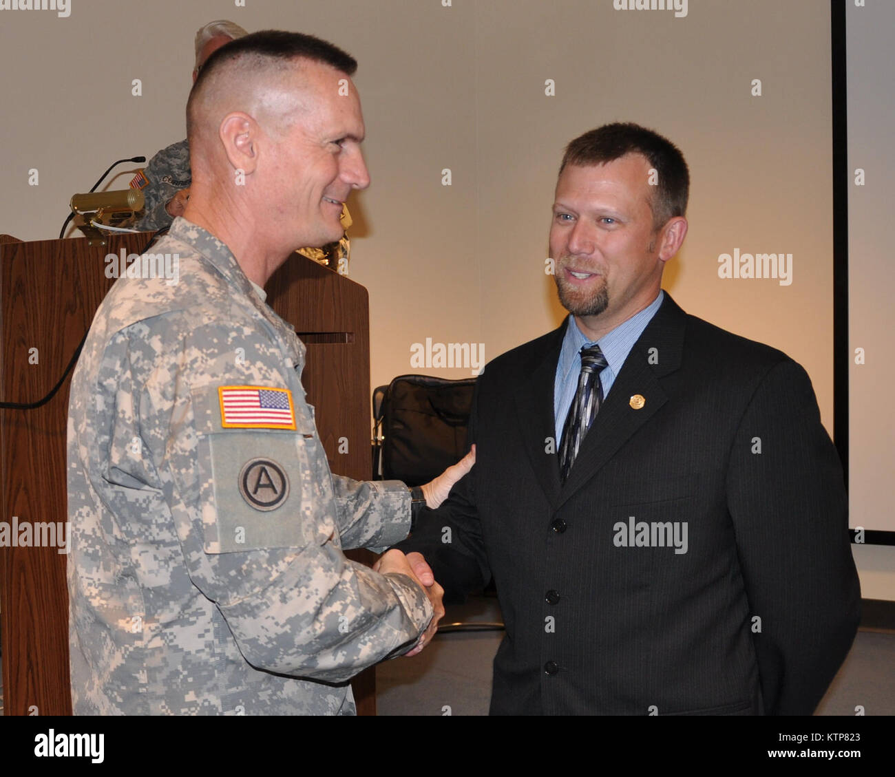 LATHAM, NY -- Major General Patrick A. Murphy, Adjutant General of the New York National Guard congratulates NYS Division of Military and Naval Affairs Office of Administrative Services employee Greg Carpenter after presenting him with the Adjutant General's Award during an award ceremony here on May 23. Stock Photo