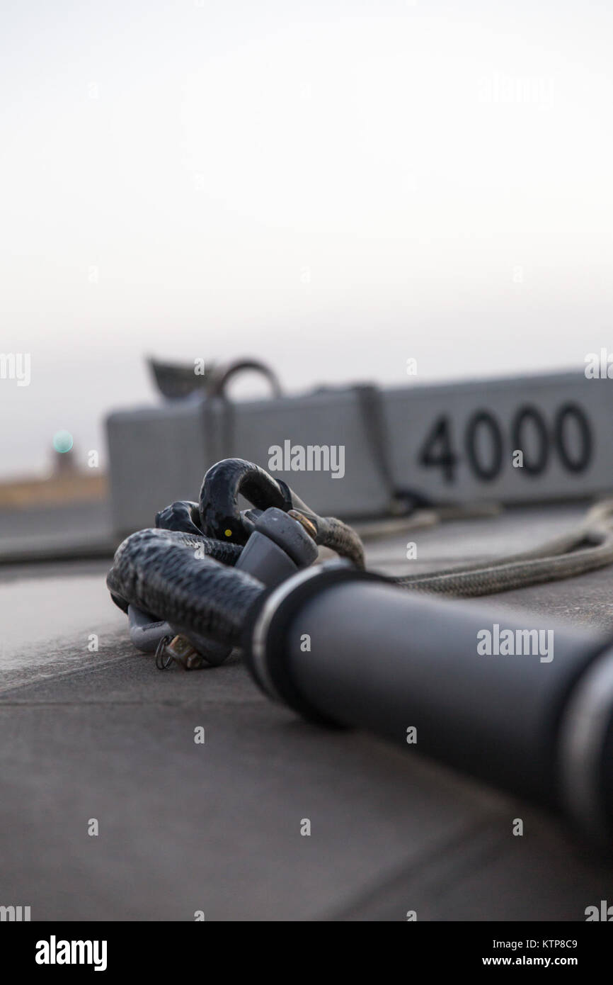 Soldiers from the 642nd Aviation Support Battalion hook up sling legs to a 4,000 lb. weight before night sling load training with aviators from 3rd Battalion, 142nd Assault Helicopter Battalion, on June 5, 2014, in Camp Buehring, Kuwait.  The 642nd and 142nd, both under the 42nd Combat Aviation Brigade, New York Army National Guard, are deployed to Kuwait in support of Operation Enduring Freedom. (N.Y. Army National Guard photo by Sgt. Harley Jelis/Released) Stock Photo