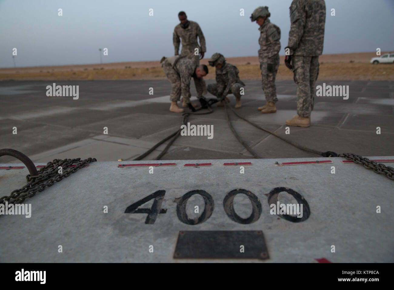 Soldiers from the 642nd Aviation Support Battalion hook up sling legs to a 4,000 lb. weight before night sling load training with aviators from 3rd Battalion, 142nd Assault Helicopter Battalion, on June 5, 2014, in Camp Buehring, Kuwait.  The 642nd and 142nd, both under the 42nd Combat Aviation Brigade, New York Army National Guard, are deployed to Kuwait in support of Operation Enduring Freedom. (N.Y. Army National Guard photo by Sgt. Harley Jelis/Released) Stock Photo