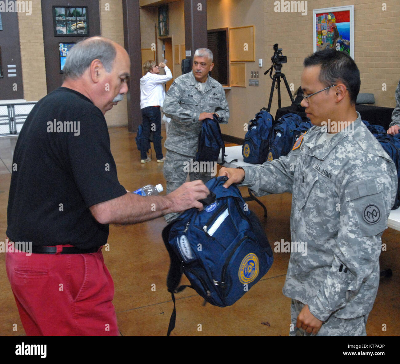 ROCHESTER, N.Y. -- New York Army National Guard 1st Lt. Thai-Bao Ngo (right) gives Dave Baxter (left) a free disaster and emergency response starter kit after a session of New York Governor Andrew Cuomo's Citizen Preparedness Corps Training Program at the Aquinas Institute of Rochester here on July 26, 2014. New York National Guard troops gave disaster and emergency training to about 250 people who attended the event. The program is designed to give citizens the knowledge and tools to prepare for emergencies and disasters, respond accordingly, and recover as quickly as possible to pre-disaster Stock Photo