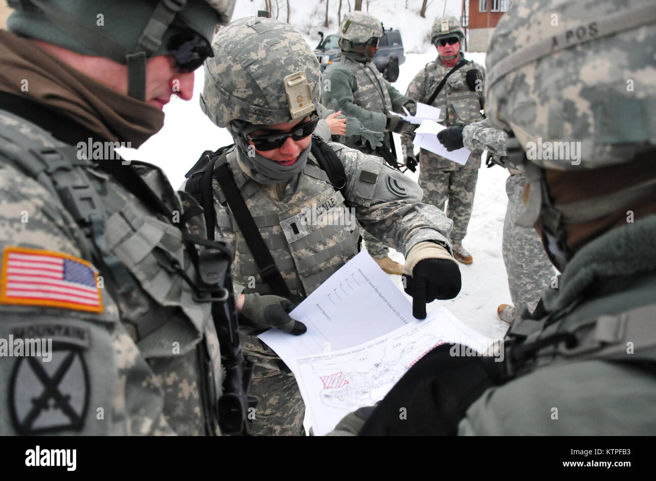 1st Lt. Yvette Valle assists her group in starting to plot out points on the map they were just given in preparation for a snowy land navigation course at Camp Smith Training Site on Feb. 23. Valle is among a group of 42nd Infantry Division Soldiers that are preparing to deploy to Guantanamo Bay, Cuba. Photo by Sgt. 1st Class Steven Petibone, 42nd Infantry Division. Stock Photo