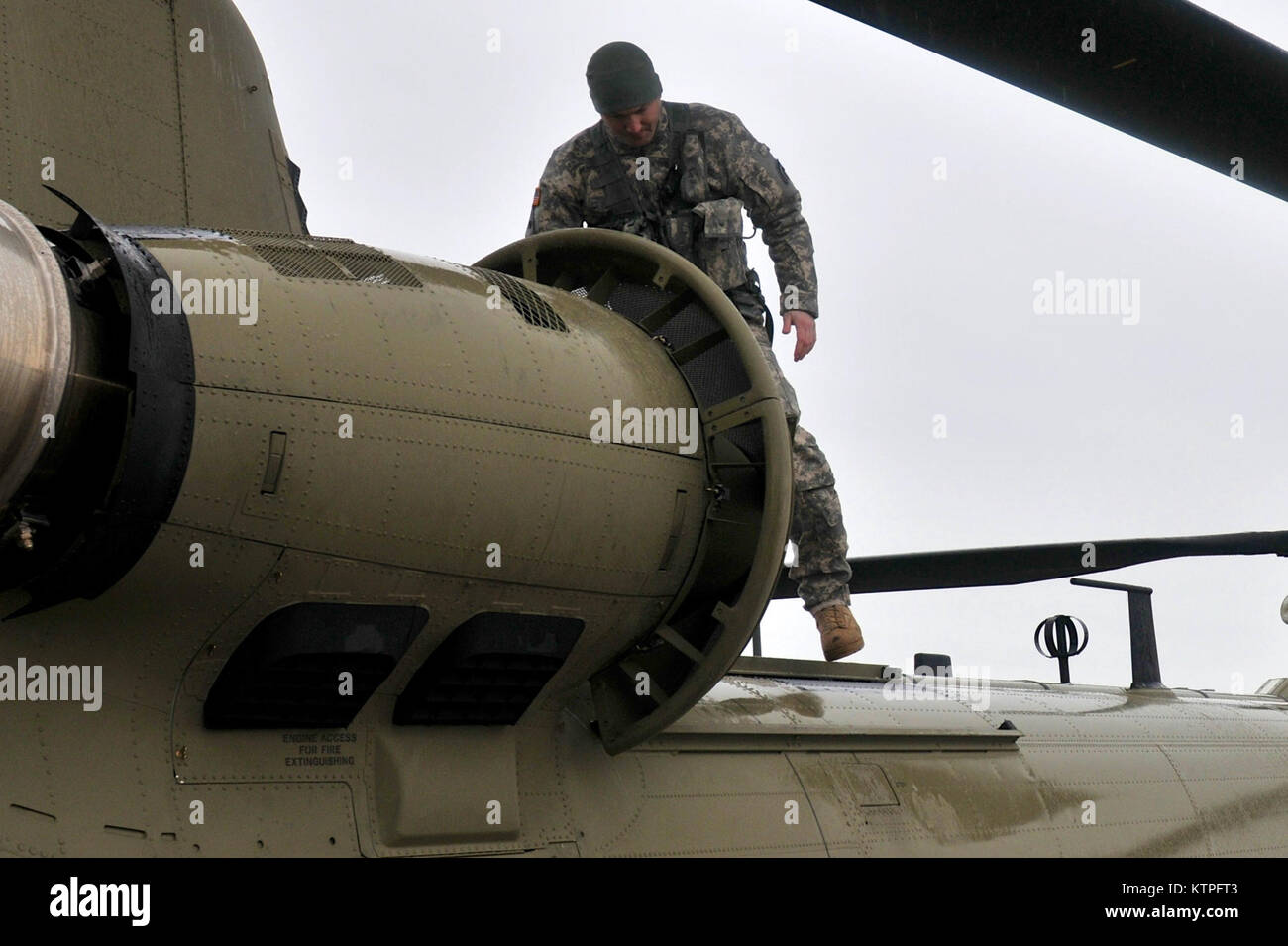 SYRACUSE, NY - Army Staff Sgt. Mike Landaur completes a safety check of a CH-47F Chinook Helicopter on March 14, 2015. Staff Sgt. Landaur is a CH-47F crew chief from Company B, 3rd Battalion, 126th Aviation based at the Army Aviation Support Facility at Rochester International Airport. 30 Airmen from the 274th Air Support Operations Squadron (ASOS), based at Hancock Field Air National Guard Base and the Army aircrew trained together for the first time. The training included Joint Terminal Attack Controller (or JTAC) Airmen from the 274th ASOS conducting CH-47 helicopter familiarization trainin Stock Photo