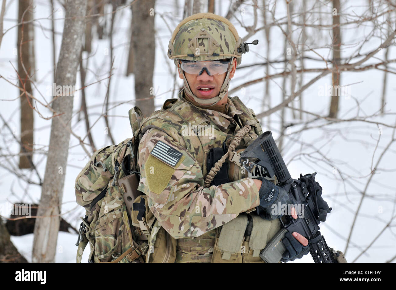 FORT DRUM, NY – Senior Airman Joel Ramirez,a Tactical Air Control Party (TACP) Airman, moves towards the objective training area during an exercise at Fort Drum, NY on March 14, 2015. 30 Airmen from the New York Air National Guard’s 274th Air Support Operations Squadron (ASOS), based at Hancock Field Air National Guard Base trained on Close Air Support (CAS) as well as training for the first time with two CH-47F Chinook helicopters from Company B, 3rd Battalion, 126th Aviation based in Rochester, NY. The 274th mission is to advise US Army commanders on how to best utilize US and NATO assets fo Stock Photo