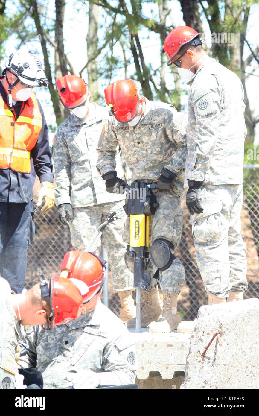 U.S. Army Spec. Andrew Hisel uses a jack hammer to break through