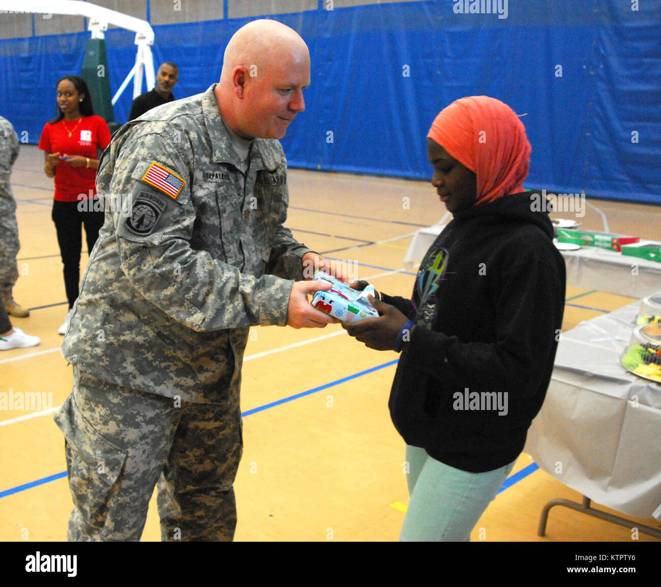 Maj. John Fitzpatrick, 369th Sustainment Brigade, presents a gift to a