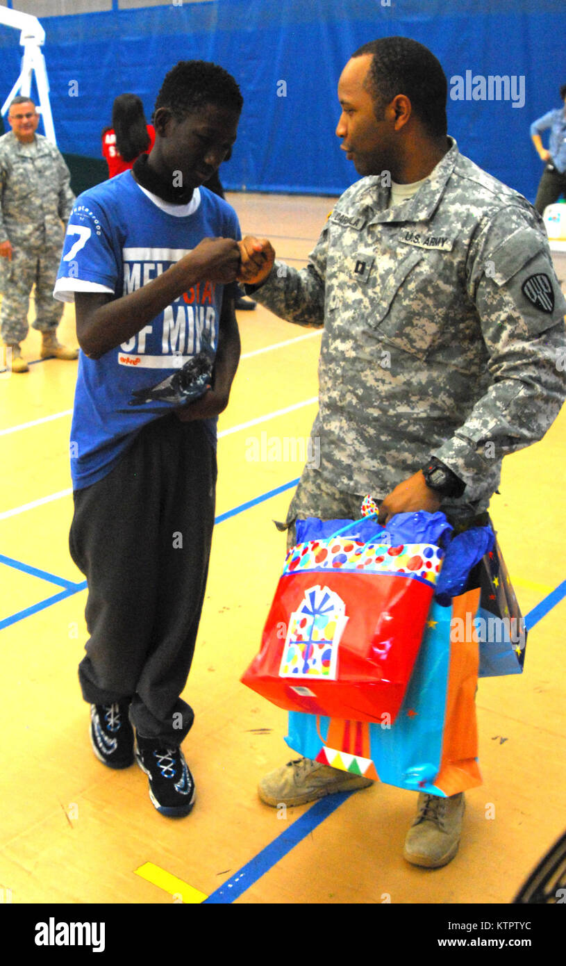 Capt. Oyeyemi Daramola, 369th Sustainment Brigade, presents a gift to a