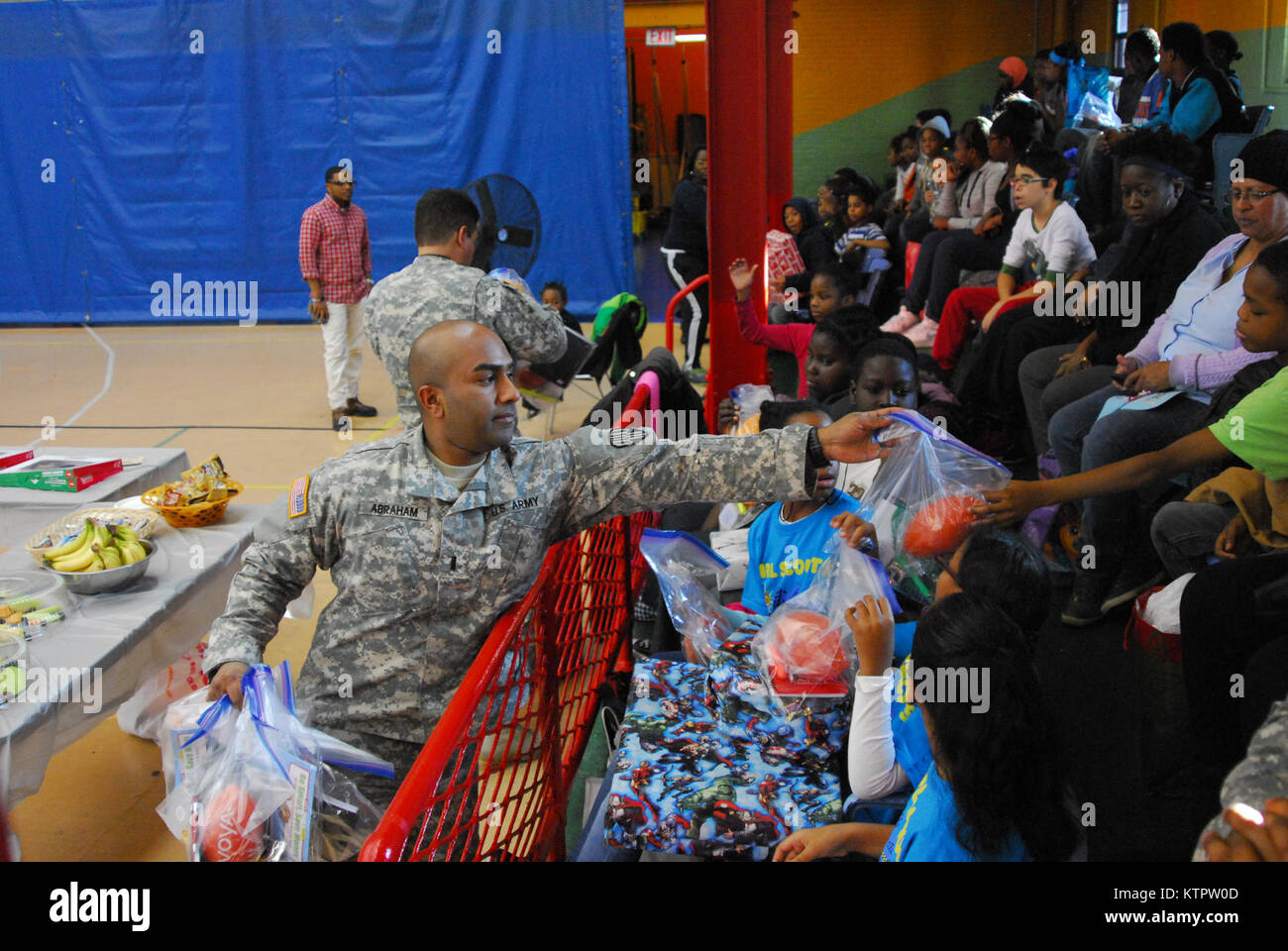 1st Lt. James Abraham, 369th Sustainment Brigade, hands out gifts to