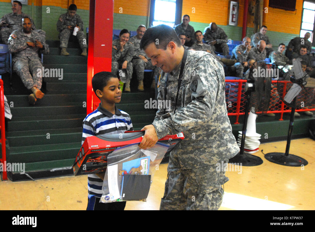 Capt. John Mancini, 369th Sustainment Brigade, presents a gift to a