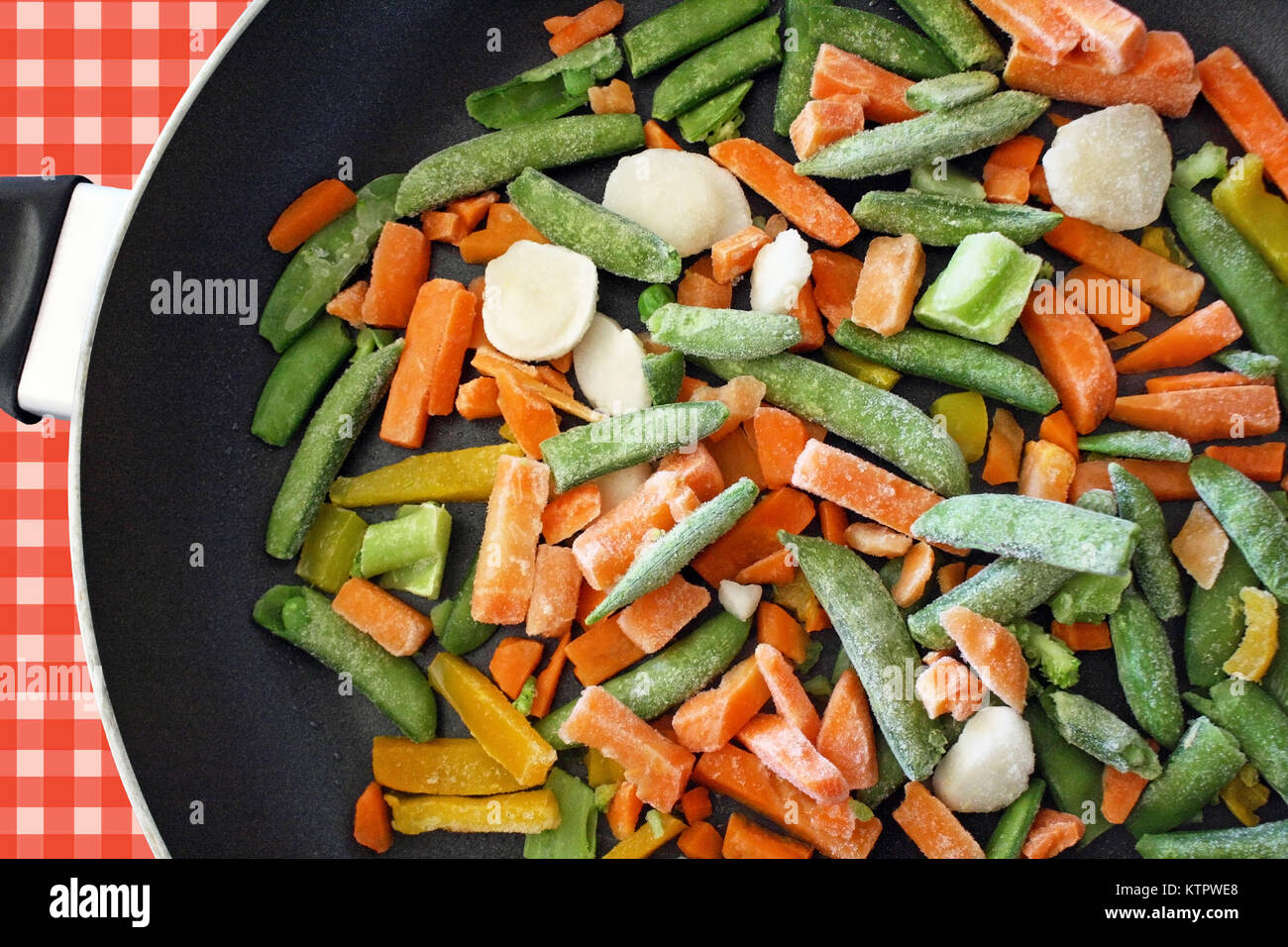 A mixture of assorted frozen veggies in skillet ready for cooking Stock Photo