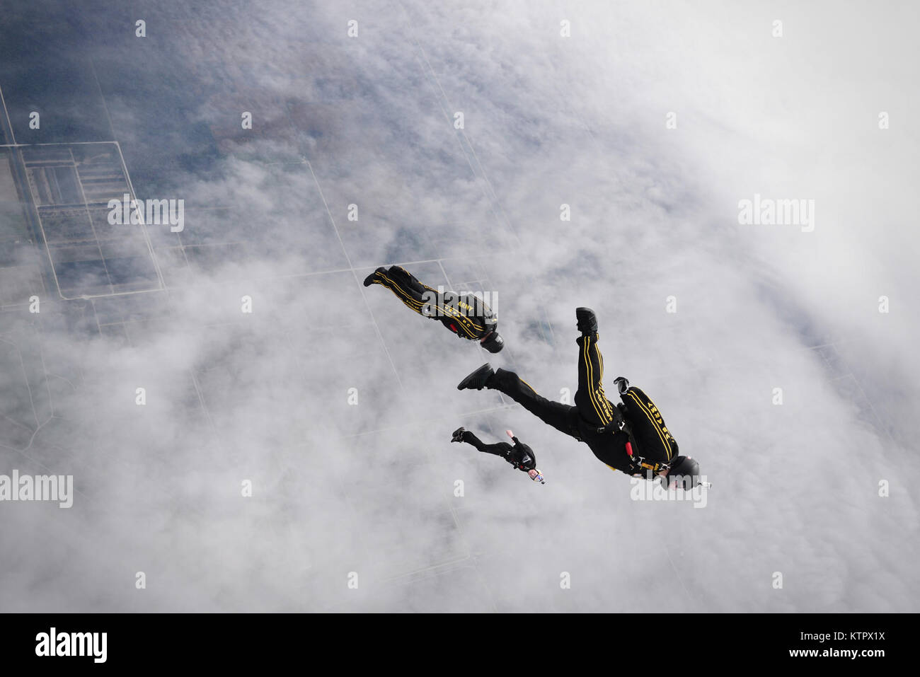 HOMESTEAD AIR RESERVE BASE, FL - Staff Sgt. Brandon Parra, Specialist Jason Winger and instructor Mike Sanson, all members of the Army's Golden Knights demonstration team, conduct a training jump over Homestead Air Reserve Base on January 19, 2016.  (US Air National Guard / Staff Sgt. Christopher S. Muncy / released) Stock Photo