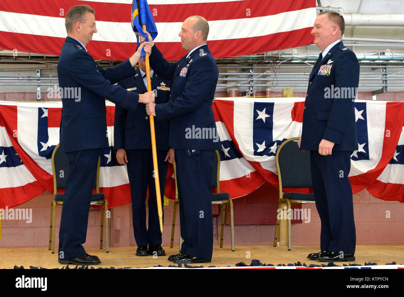 Maj. Gen. Anthony German, New York National Guard Adjutant General, hands the 106th Rescue Wing guidon to Col. Michael Bank, 106th RQW commander, at a change-of-command ceremony at Francis S. Gabreski Airport, April 2. Bank took over command of the 106th from Brig. Gen. Thomas Owens, who has moved on to Assistant Adjutant General for Air at the Joint Force Headquarters in Latham, N.Y. Stock Photo