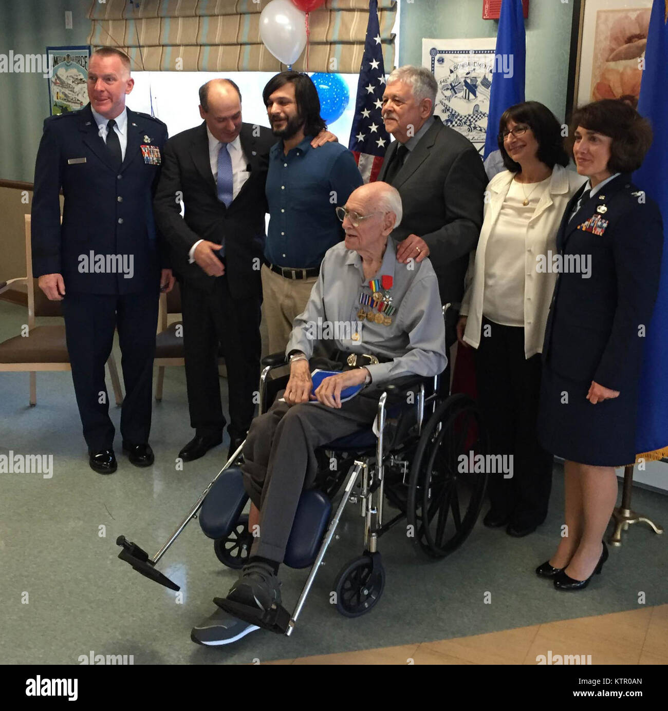 New York Air National Guard Brig. Gen. Thomas Owens (left), the Deputy Adjutant General for Air; French representative Col Frederic Vigneron; and Col. Mauren Murphy, Chief of Staff of the New York Air National Guard (far right)  pose with former United States Army Air Forces Capt. Harold Smith,age 98,  and his family at the Garden Care Health Facility in  Franklin Square, N.Y. on June 6, 2016. Vigneron presented Smith with the French Legion of Honor in recognition of the war the one-time B-24 and B-29 navigator played in Liberating France from German occupation during World War II. Smith, who  Stock Photo