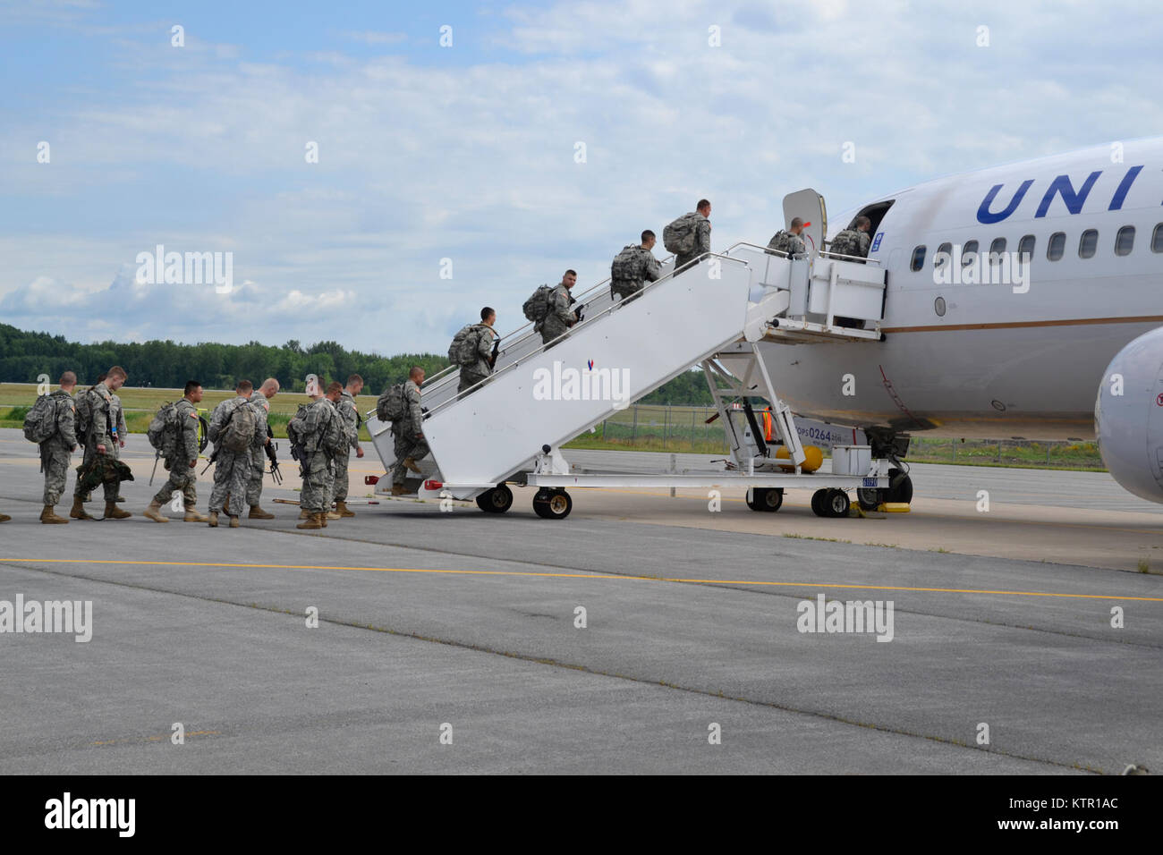 Soldiers assigned to the New York Army National Guard's 27th Infantry Brigade Combat Team board a charter aircraft on Saturday, July 9, 2016 at Hancock Field Air National Guard Base in Syracuse, N.Y. The Soldiers are heading to Fort Polk, Louisiana for a three week exercise at the Joint Readiness Training Center there. ( U.S. Air National Guard photo by Master Sgt. Eric Miller/ Released) Stock Photo