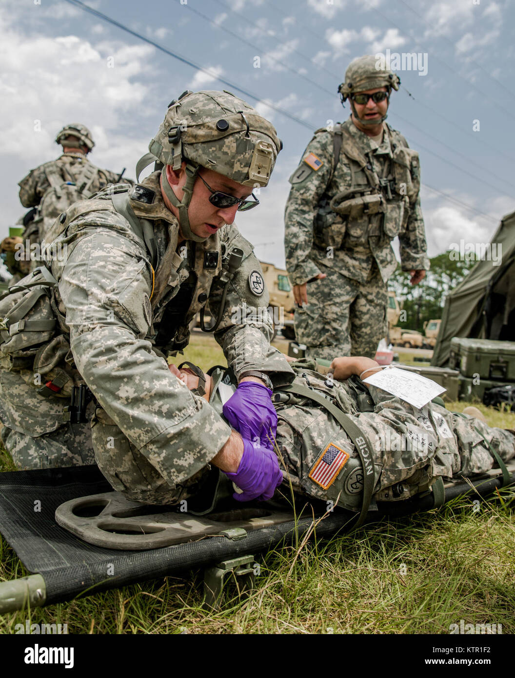 New York Army National Guard medics, assigned to Headquarters Co., 1st Battalion, 69th Infantry support a Soldier with a simulated back injury during a mass casualty exercise at the Army’s Joint Readiness Training Center, Fort Polk, La., Saturday, July 16, 2016. More than 3,000 New York Army National Guard Soldiers deployed for a three week exercise at the Army’s Joint Readiness Training Center, July 9-30, 2016. U.S. Army National Guard photo by Sgt. Harley Jelis. Stock Photo